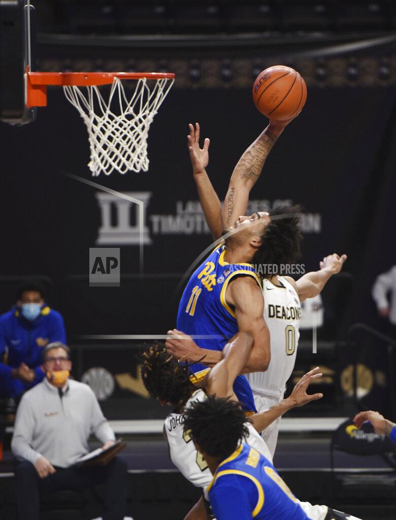 Walt Unks Pittburgh's Justin Champagnie drives to the basket past Wake Forest Jalen Johnson (2) and Jahcobi Neath (0) during an NCAA college basketball game Saturday, Jan. 23, 2021, in Winston-Salem, N.C. (Walt Unks/The Winston-Salem Journal via AP)