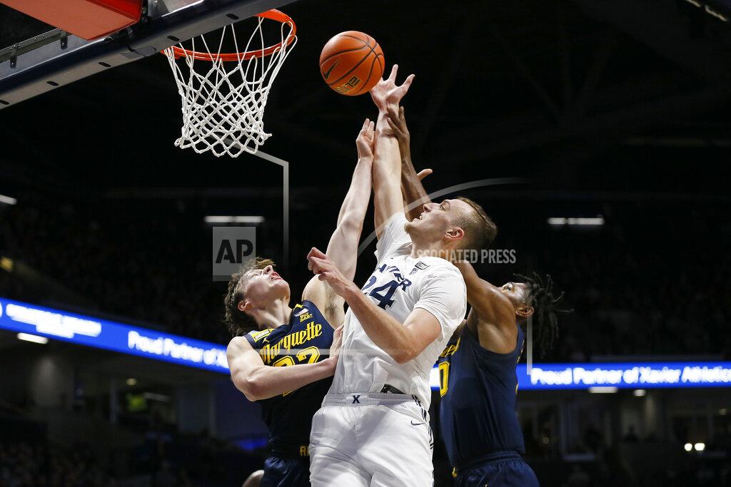 Sam Greene Xavier forward Jack Nunge (24) stretches for a rebound against Marquette guard Tyler Kolek (22) in the first half of an NCAA college basketball game at Cintas Center in Cincinnati on Saturday, Dec. 18, 2021. (Sam Greene/The Cincinnati Enquirer via AP)