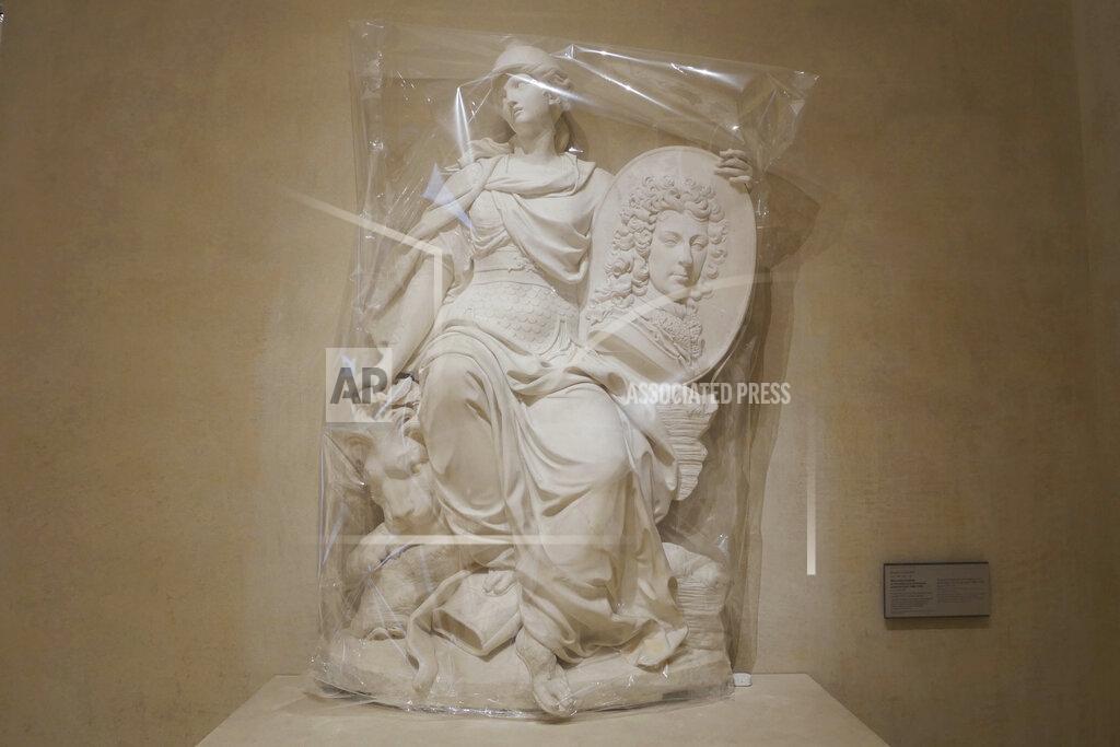 Thibault Camus The sculpture called 'Funerary monument to Francois-Louis de Bourbon, Prince de Conti' by French sculptor Nicolas Coustou is covered with plastic sheeting, at the Louvre museum in Paris, Thursday, Feb. 11, 2021. (AP Photo/Thibault Camus)