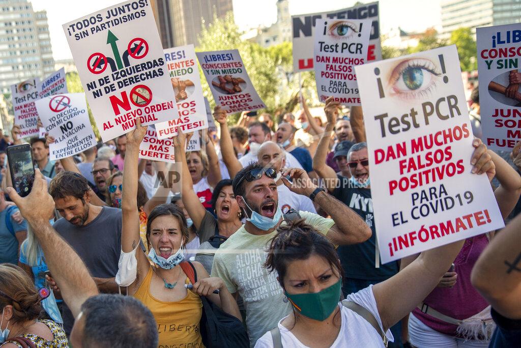 Andrea Comas FILE - In this Aug. 16, 2020, file photo, demonstrators attend a protest against nationwide restrictions against COVID-19 in Madrid, Spain. Banners read in Spanish "PCR tests give many false positives for COVID-19. Inform yourself." After shutdowns swept nations during the virus's first surge earlier this year, some nations and U.S. states are trying more targeted measures as cases rise again around the world, especially in Europe and the Americas. (AP Photo/Andrea Comas, File)