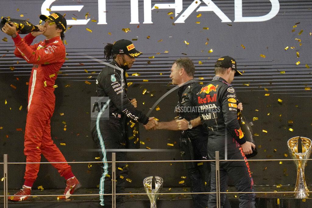 Hassan Ammar Red Bull team chief Christian Horner shakes hands with Mercedes driver Lewis Hamilton of Britain after his driver Max Verstappen of the Netherlands, right, celebrate after he became the world champion after winning the Formula One Abu Dhabi Grand Prix in Abu Dhabi, United Arab Emirates, Sunday, Dec. 12, 2021. Max Verstappen ripped a record eighth title away from Lewis Hamilton with a pass on the final lap of the Abu Dhabi GP to close one of the most thrilling Formula One seasons in years as the first Dutch world champion. (AP Photo/Hassan Ammar)