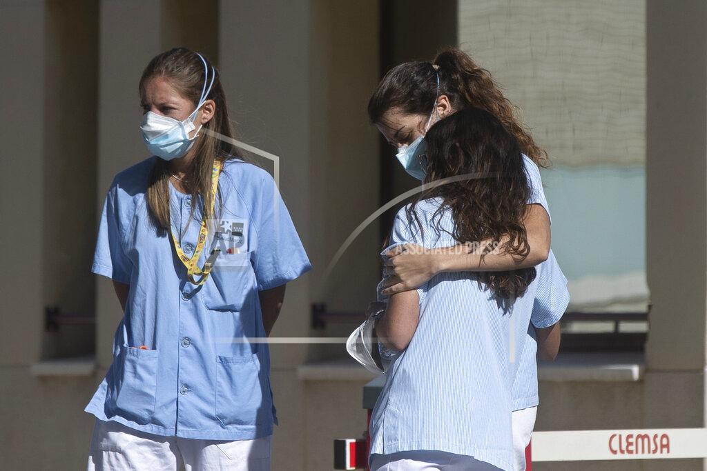 Paul White A health worker hugs her colleague during a break outside hospital in Madrid, Spain, Monday, Oct. 5, 2020. Madrid has been the source of Europe’s most worrying surge of infections in the ongoing second wave of the pandemic. (AP Photo/Paul White)