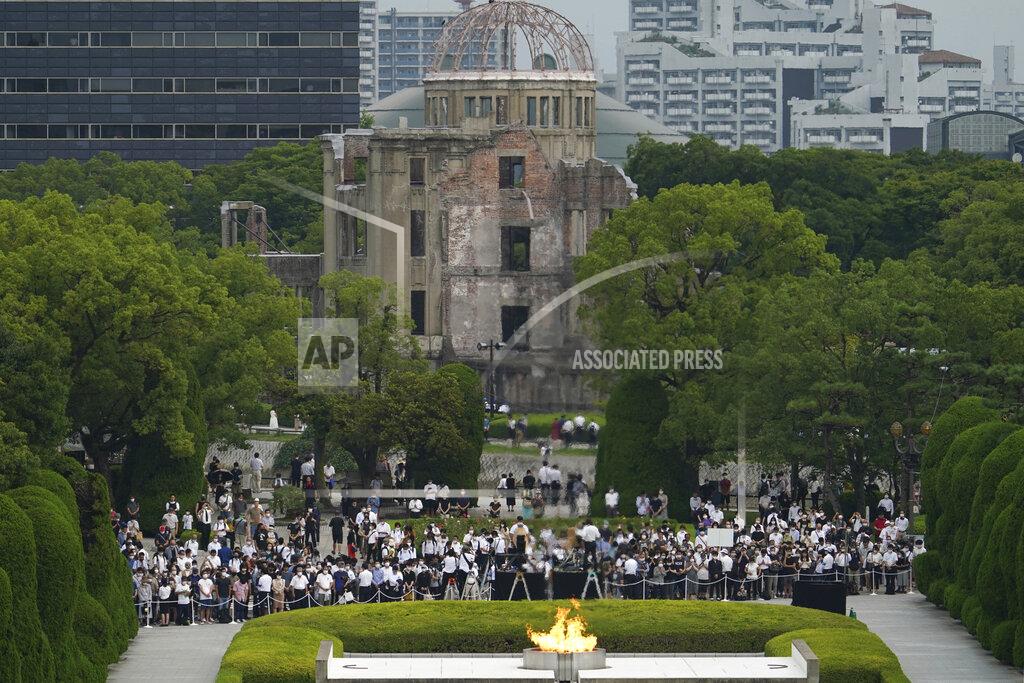 Eugene Hoshiko Visitors observe a minute of silence for the victims of the atomic bombing, at 8:15am, the time atomic bomb exploded over the city, at the Hiroshima Peace Memorial Park during the ceremony to mark the 75th anniversary of the bombing Thursday, Aug. 6, 2020, in Hiroshima, western Japan. (AP Photo/Eugene Hoshiko)