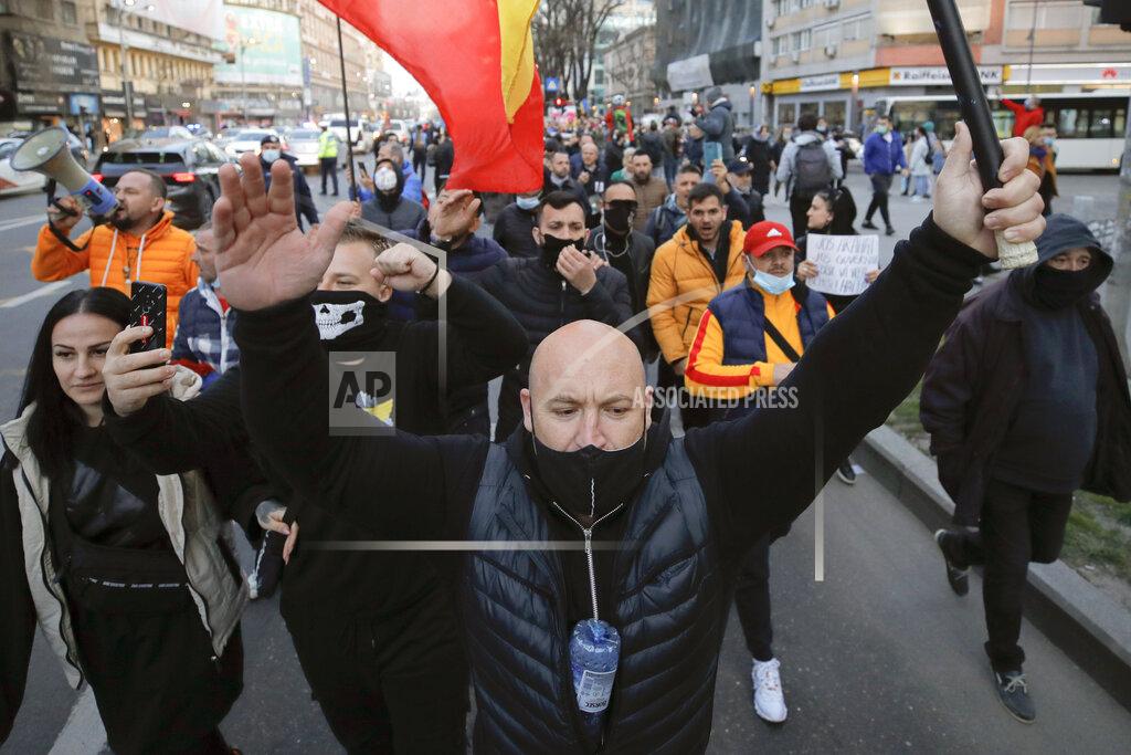 Vadim Ghirda People protesting against the COVID-19 pandemic restrictions march in downtown Bucharest, Romania, Monday, March 29, 2021. Thousands of anti-restriction protesters took to the streets in several cities across Romania on Monday evening, a day after new restriction measures came into force. (AP Photo/Vadim Ghirda)