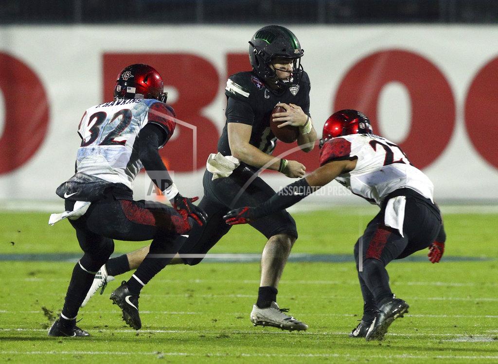 Richard W. Rodriguez Ohio quarterback Nathan Rourke (12) carries the ball against San Diego State cornerback Tayler Hawkins (32) and cornerback Kyree Woods (27) in the second half of the Frisco Bowl NCAA college football game, Wednesday, Dec. 19, 2018, in Frisco, Texas. (AP Photo/Richard W. Rodriguez)