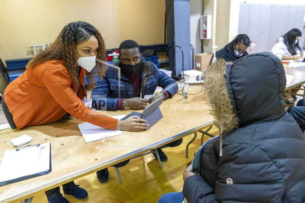 Mary Altaffer Crismely Tinidad, left, the Housing Service Coordinator at the Bronx River Community Center, translates for a resident who only speaks Spanish as he registers with a Somos Community Care screener at a pop-up COVID-19 vaccination site at the Bronx River Addition NYCHA complex, Sunday, Jan. 31, 2021, in the Bronx borough of New York. From elderly Cuban Americans in Florida to farmworkers in California, Latinos face daunting barriers like fear, language and a lack of education and access as the COVID-19 vaccines roll out, creating risks for public health as the virus mutates and spreads. (AP Photo/Mary Altaffer)