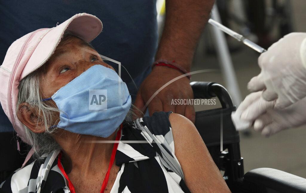 Marco Ugarte An elderly woman looks at a health worker before getting her shot of the Sinovac Biotech COVID-19 vaccine at the Americas sports center in Ecatepec, a borough on the outskirts of Mexico City, Tuesday, Feb. 23, 2021. (Foto AP/Marco Ugarte)
