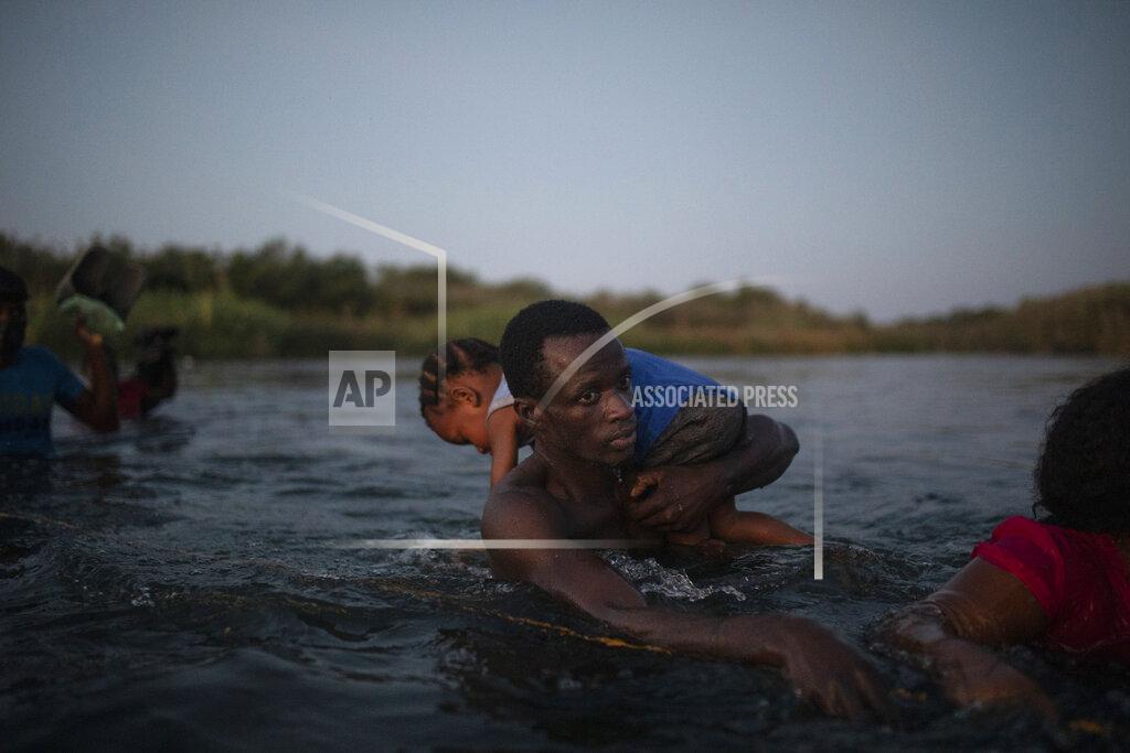 Felix Marquez Migrants wade across the Rio Grande from Del Rio, Texas, to Ciudad Acuña, Mexico, Sunday, Sept. 19, 2021. (AP Photo/Felix Marquez)