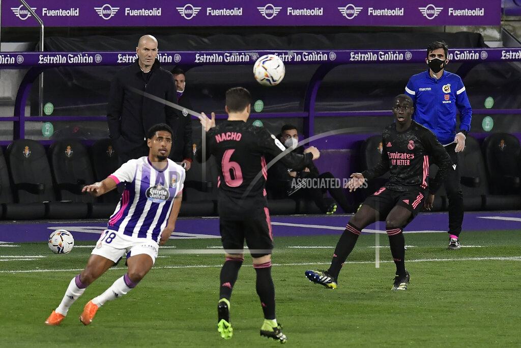 Alvaro Barrientos Real Madrid's head coach Zinedine Zidane, background left, watches Real Madrid's Nacho heads the ball during the Spanish La Liga soccer match between Valladolid and Real Madrid at the Jose Zorrila stadium in Valladolid, Spain, Saturday, Feb. 20, 2021. (AP Photo/Alvaro Barrientos)