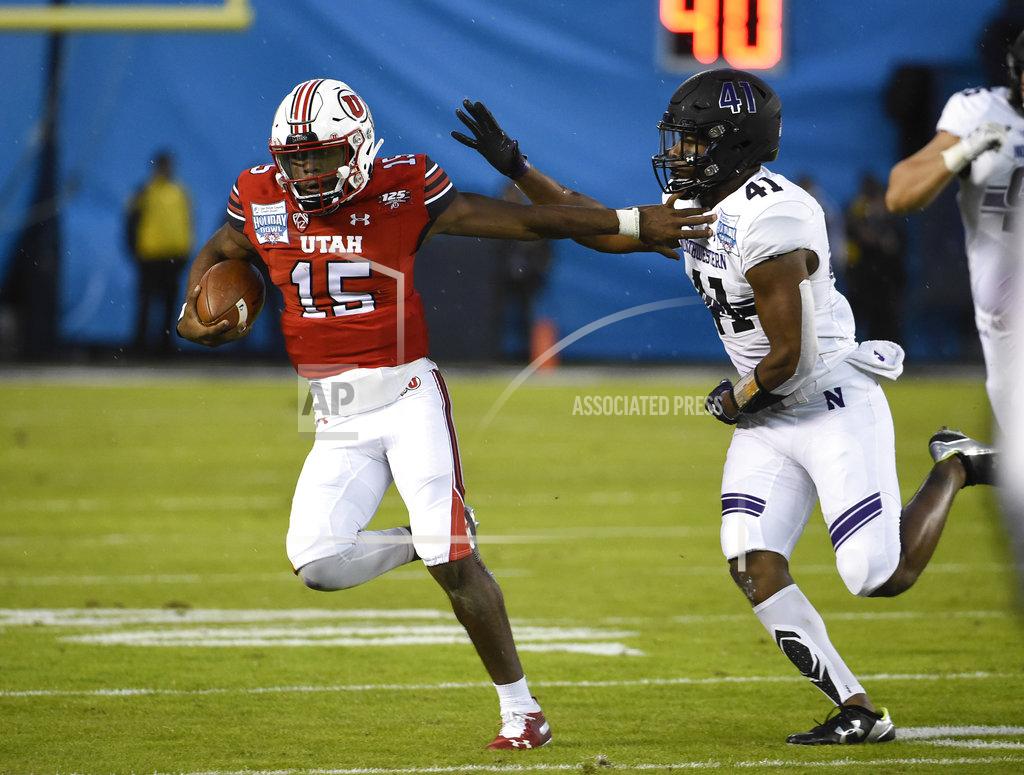 Denis Poroy Utah quarterback Jason Shelley (15) runs away from Northwestern safety Jared McGee (41) on his way to a first down during the first half of the Holiday Bowl NCAA college football game Monday, Dec. 31, 2018, in San Diego. (AP Photo/Denis Poroy)