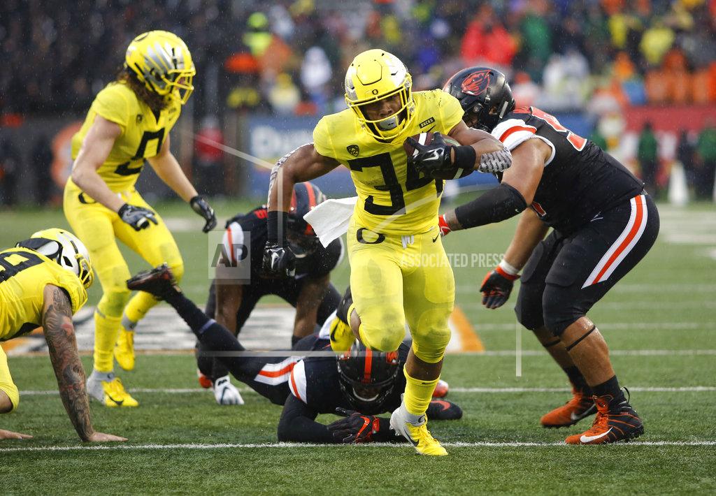 Timothy J. Gonzalez Oregon running back C.J. Verdell (34) breaks through the Oregon State defensive line for a touchdown during the second half of an NCAA college football game in Corvallis, Ore., Friday, Nov. 23, 2018. Oregon won 55-15. (AP Photo/Timothy J. Gonzalez)