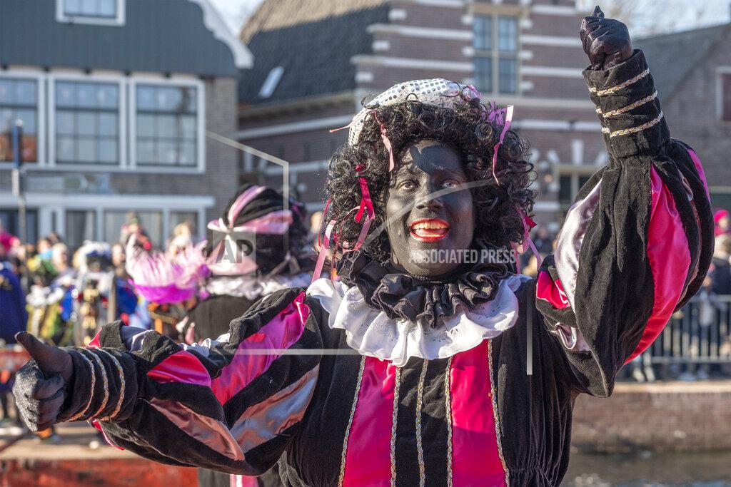 Patrick Post FILE - In this Saturday, Nov. 17, 2018, file photo, a Black Pete interacts with children during the arrival of Sinterklaas in Monnickendam, Netherlands. Facebook announced Tuesday, Aug. 11, 2020, that it is banning caricatures of Black people in the form of blackface, as well as dehumanizing depictions of Jewish people that include images or posts of Jewish people running the world or controlling major institutions such as media networks, the economy or the government. Zwarte Piet is a sidekick of Sinterklaas, the Dutch version of St. Nicholas a Santa-like character who brings children gifts. (AP Photo/Patrick Post, File)