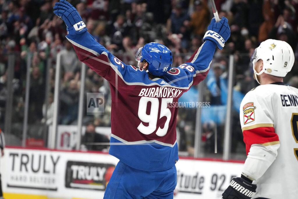 David Zalubowski Colorado Avalanche left wing Andre Burakovsky, left, turns and celebrates after netting a goal for his first career hat trick as Florida Panthers center Sam Bennett looks on in the third period of an NHL hockey game Sunday, Dec. 12, 2021, in Denver. Colorado won 3-2. (AP Photo/David Zalubowski)