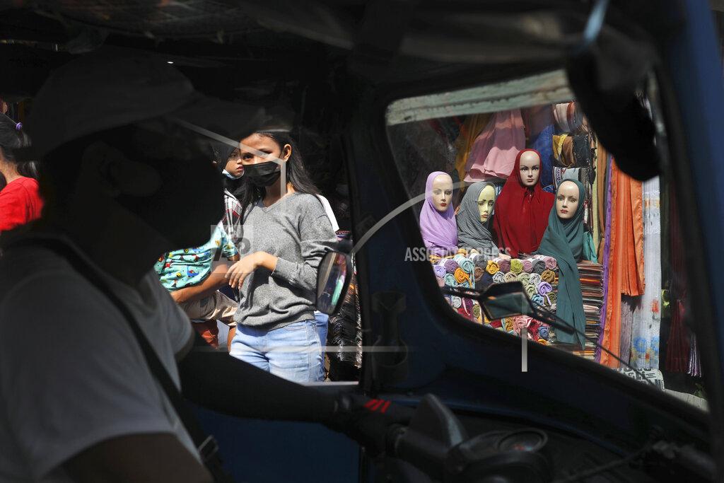 Dita Alangkara Mannequins and women wearing masks to curb the spread of coronavirus outbreak are seen through the windows of a three-wheeled motorized taxi called "bajaj", during the last week of Ramadan at a market in Jakarta, Indonesia, Tuesday, May 4, 2021. People flock markets and shopping malls in the capital as they shop for food and new clothings in preparation for Eid al Fitr holiday that marks the end of the holiest month in Islamic calendar. (AP Photo/Dita Alangkara)