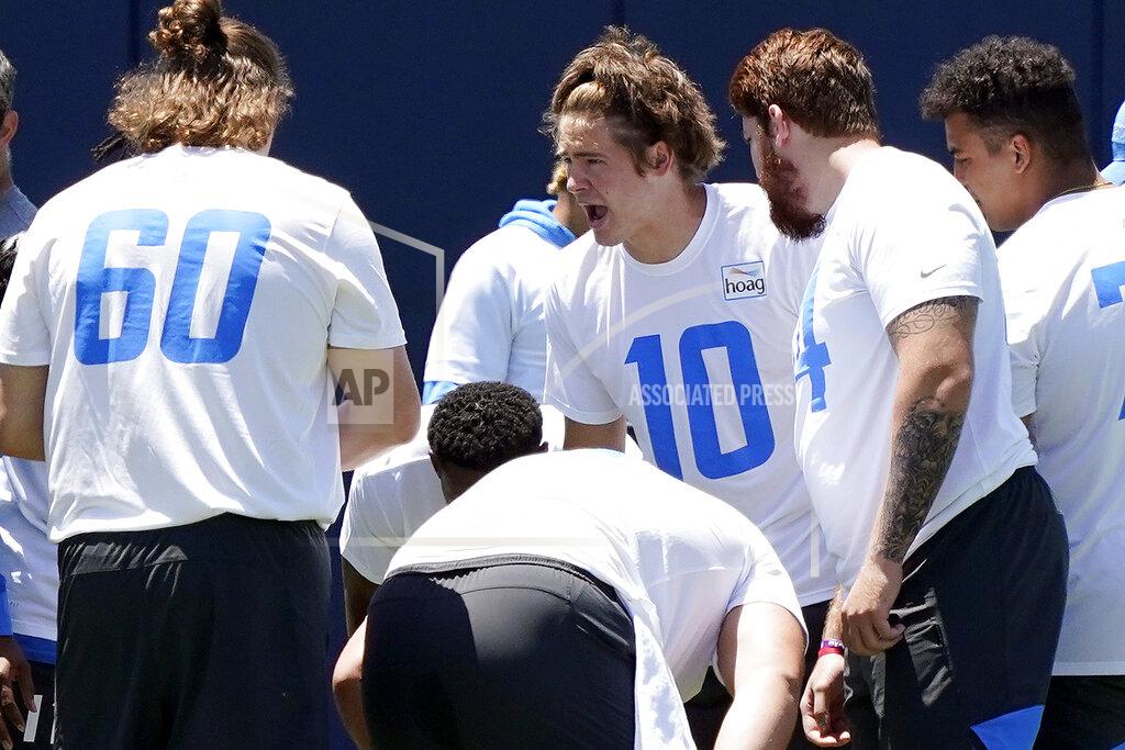 Los Angeles Chargers quarterback Justin Herbert (10) huddles with teammates during the NFL football team's organized team activities Monday, May 24, 2021, in Costa Mesa, Calif. (AP Photo/Marcio Jose Sanchez)