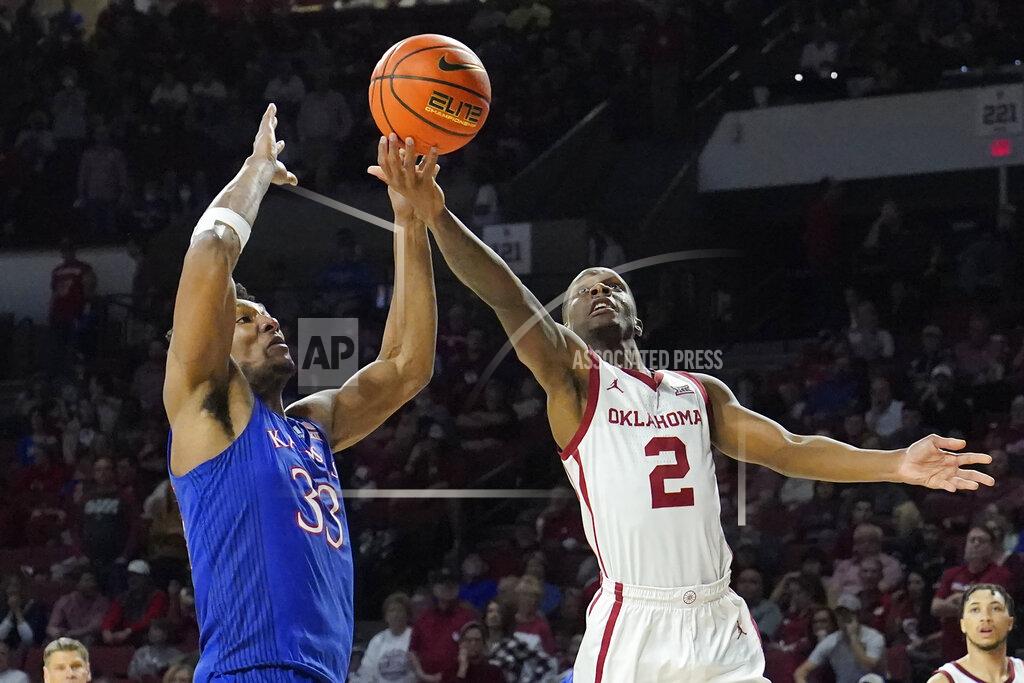 Sue Ogrocki Oklahoma guard Umoja Gibson (2) goes to the basket in front of Kansas forward David McCormack (33) in the second half of an NCAA college basketball game Tuesday, Jan. 18, 2022, in Norman, Okla. (AP Photo/Sue Ogrocki)