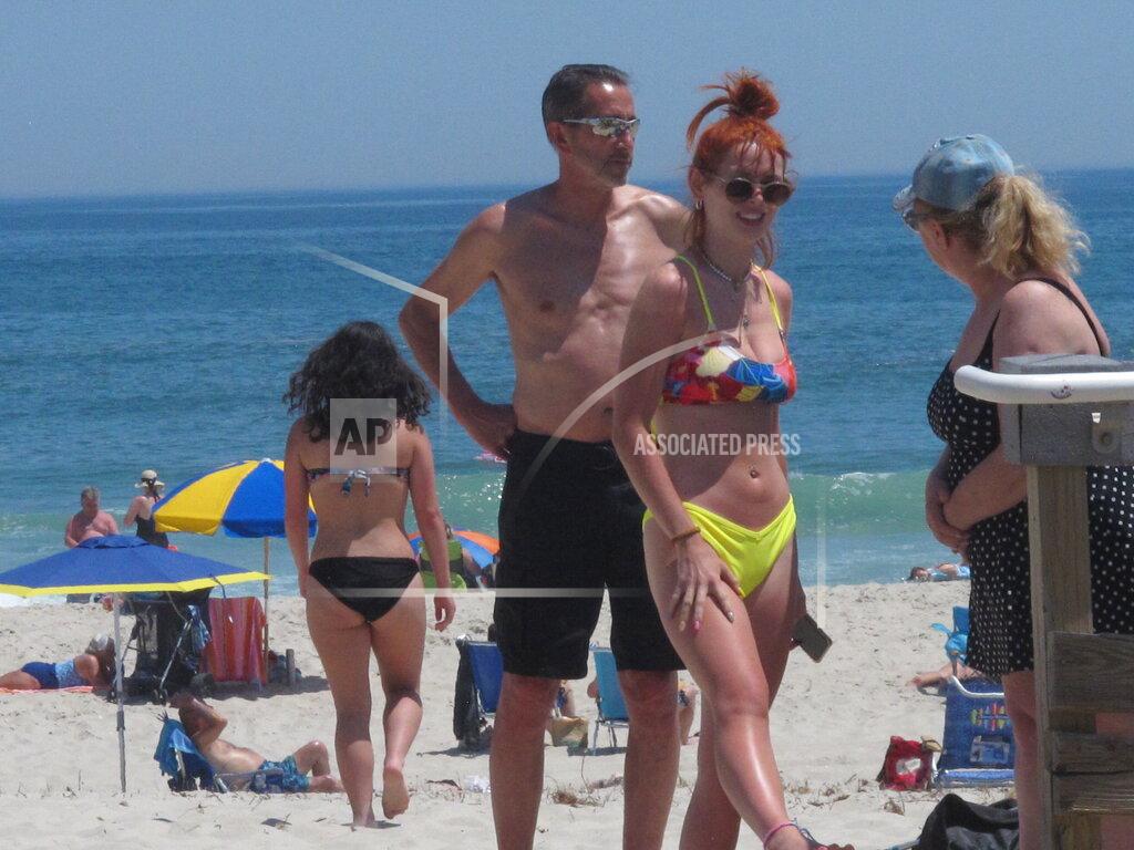 Beachgoers stand on Island Beach State Park in New Jersey as Gov. Phil Murphy announced that the state will give free season-long admission to the park and other state parks to any New Jersey resident who has gotten at least one dose of COVID-19 vaccine by July 4 on Wednesday, May 19, 2021. (AP Photo/Wayne Parry)