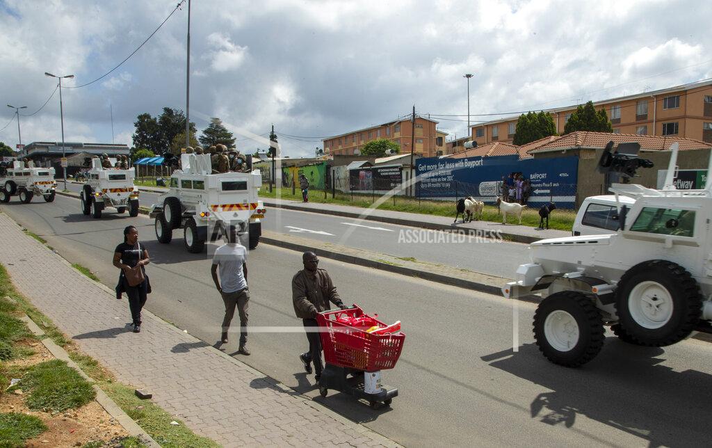 Themba Hadebe A man pushing a shopping cart with food on the street as South African National Defence Forces drive through a densely populated Alexandra township east of Johannesburg, South Africa, Saturday, March 28, 2020. South Africa went into a nationwide lockdown for 21 days in an effort to control the spread of the COVID-19 coronavirus. The new coronavirus causes mild or moderate symptoms for most people, but for some, especially older adults and people with existing health problems, it can cause more severe illness or death. (AP Photo/Themba Hadebe)