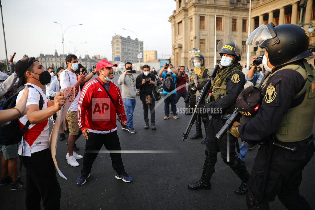 Rodrigo Abd Supporters of ousted President Martin Vizcarra shout at police in front of the Justice Palace in Lima, Peru, Wednesday, Nov. 11, 2020. On Tuesday, Peru swore in Manuel Merino as president, after Peru’s legislature booted Vizcarra from office on Monday. (AP Photo/Rodrigo Abd)