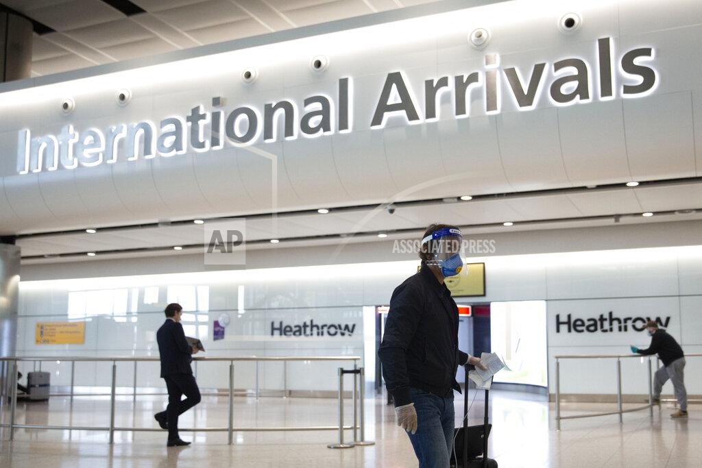 Matt Dunham A passenger wearing a face shield and face mask arrives on the first day of new rules that people arriving in Britain from overseas will have to quarantine themselves for 14 days to help stop the spread of coronavirus, at Heathrow Airport in London, Monday, June 8, 2020. The British government has said that anyone caught not complying with the quarantine will face a fine. (AP Photo/Matt Dunham)