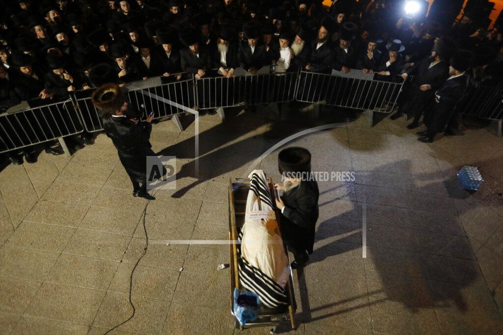 Ariel Schalit Ultra-Orthodox mourners gather around the body of Menachem Knoblowitz, 21, from the United States, who died during Lag BaOmer celebrations at Mt. Meron in northern Israel, at his funeral in Jerusalem on Saturday, May 1 2021. A stampede at a religious festival attended by tens of thousands of ultra-Orthodox Jews in northern Israel killed dozens of people and injured about 150 early Friday, medical officials said. It was one of the country's deadliest civilian disasters. (AP Photo/Ariel Schalit)