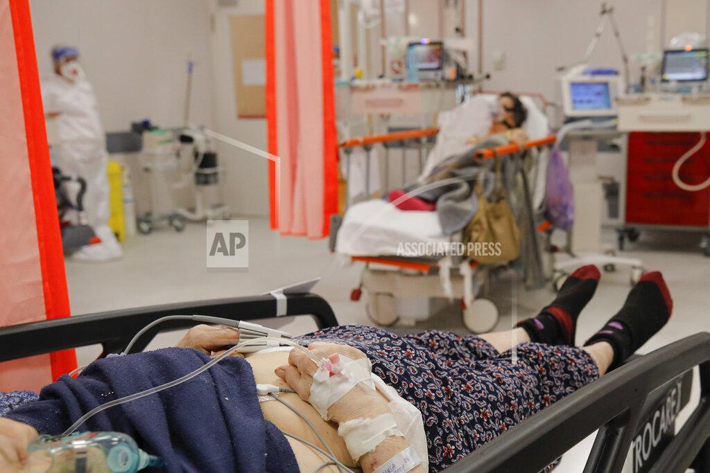 Andreea Alexandru Patients lie on beds in the emergency room, turned into a CODIV-19 unit due the high number of cases, at the Bagdasar-Arseni hospital in Bucharest, Romania, Tuesday, Oct. 12, 2021. Romania reported on Tuesday nearly 17,000 new COVID-19 infections and 442 deaths, the highest number of coronavirus infections and deaths in a day since the pandemic started, as the nation's health care system struggles to cope with an acute surge of new cases.(AP Photo/Andreea Alexandru)