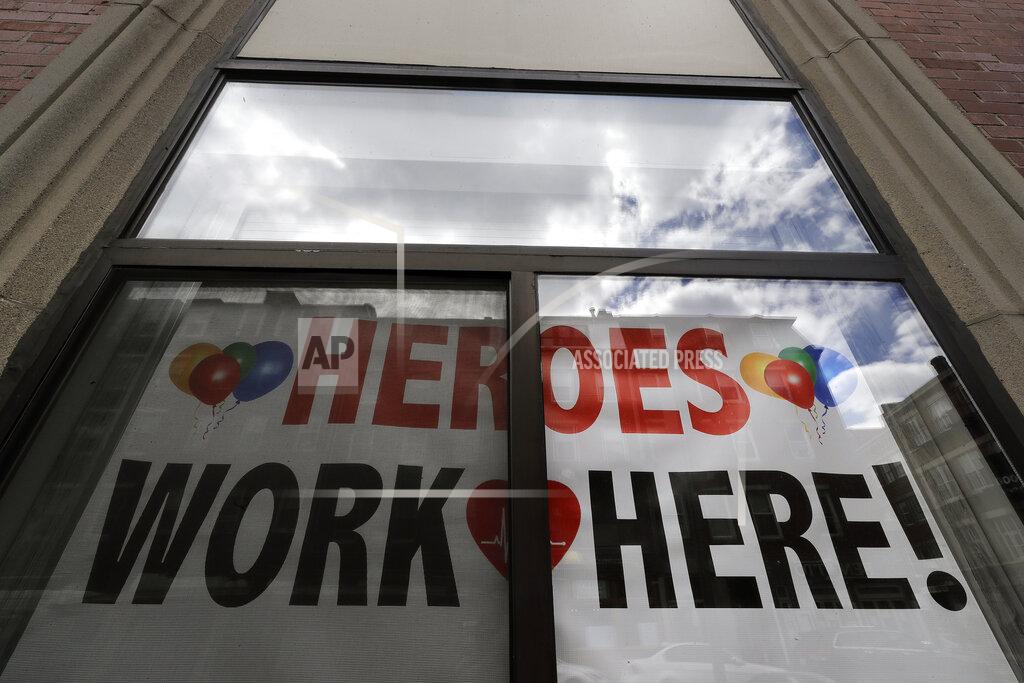Steven Senne FILE - This May 12, 2020, file photos shows a sign honoring healthcare workers in a window of Massachusetts General Hospital's North End Waterfront Health center in the North End neighborhood of Boston. As the coronavirus pandemic surges across the nation and infections and hospitalizations rise, medical administrators are scrambling to find enough nursing help — especially in rural areas and at small hospitals. (AP Photo/Steven Senne, File)