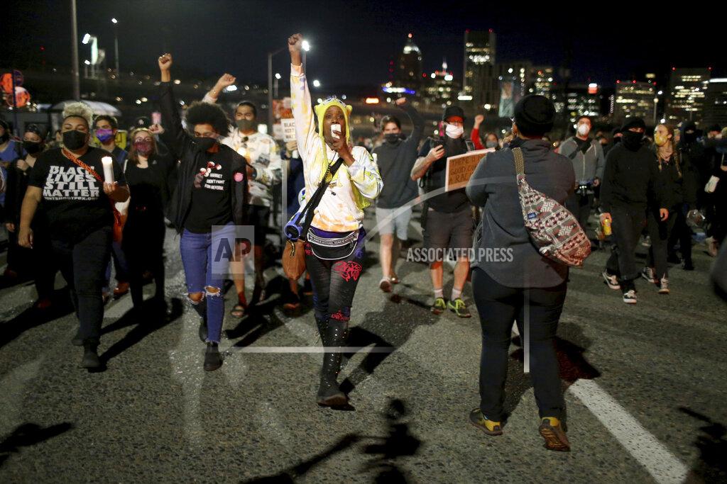 Dave Killen A group marches along the Hawthorne Bridge after meeting at Salmon Street Springs and listening to several Black and Indigenous speakers talk, Friday, April 16, 2021, in Portland, Ore. Police in Portland, said Saturday they arrested several people after declaring a riot Friday night when protesters smashed windows, burglarized businesses and set multiple fires during demonstrations that started after police fatally shot a man while responding to reports of a person with a gun. (Dave Killen/The Oregonian via AP)