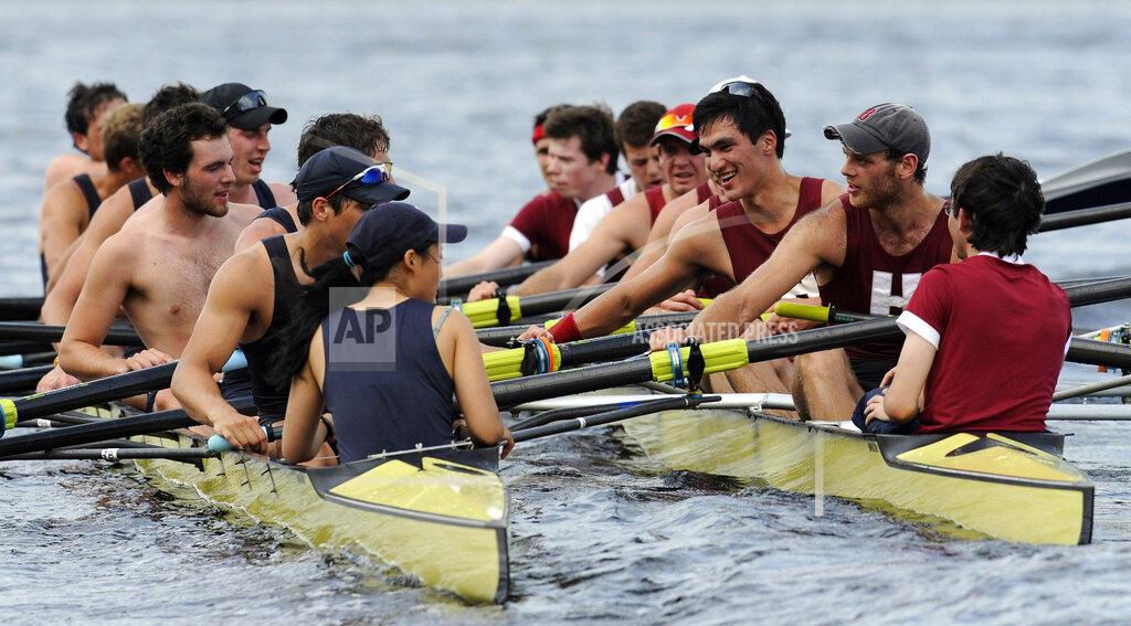 Jessica Hill FILE — Members of Yale crew, left, and Harvard crew, right, greet one another after the four-mile course along the Thames River for the 146th Harvard-Yale Regatta, in New London, Conn., Saturday, May 28, 2011. Harvard defeated Yale in the race. The 170-year-old prize awarded in the first U.S. intercollegiate sports competition is going up for auction next month. Sotheby's estimates the trophy oars from the inaugural Harvard-Yale Regatta will fetch $3-$5 million in online bidding May 17-24, 2022. (AP Photo/Jessica Hill, File)