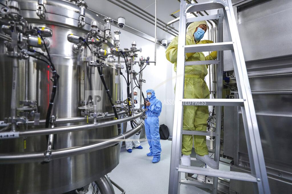 Zhang Yuwei In this April 11, 2020, photo released by Xinhua News Agency, staff members check and clean equipments at a vaccine production plant of SinoPharm in Beijing. In the global race to make a coronavirus vaccine, the state-owned Chinese company is boasting that it gave its employees, including top executives, experimental shots even before the government OK'd testing in people. (Zhang Yuwei/Xinhua via AP)
