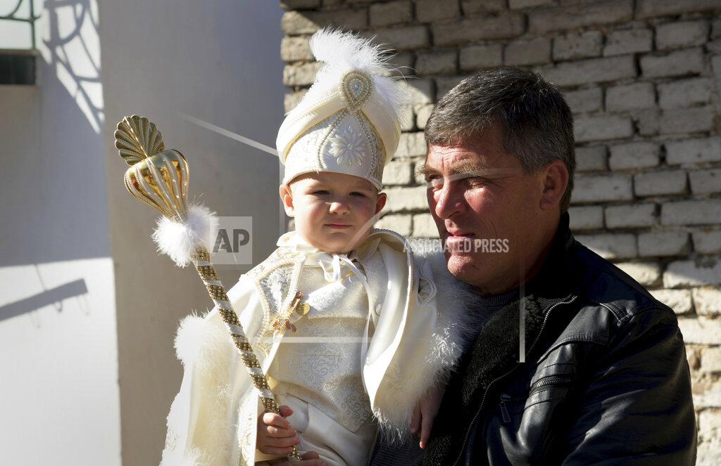 Jordan Simeonov Parent holds his child as they take part in a mass circumcision ceremony in the village of Ribnovo, Bulgaria, Sunday, April 11, 2021. Despite the dangers associated with COVID-19 and government calls to avoid large gatherings, Hundreds of people flocked to the tiny village of Ribnovo in southwestern Bulgaria for a four-day festival of feasting, music and the ritual of circumcision which is considered by Muslims a religious duty and essential part of a man's identity. (AP Photo/Jordan Simeonov)
