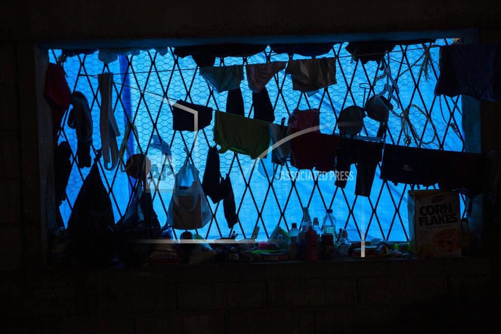 Moises Castillo Clothes hang dry inside a warehouse where a family left homeless by last year's hurricanes Eta and Iota live near the Chamelecon neighborhood of San Pedro Sula, Honduras, Tuesday, Jan. 12, 2021. The devastation wrought by November's hurricanes and the economic damage of the COVID-19 pandemic has added to the forces of poverty and gang violence that drive Hondurans to migrate. (AP Photo/Moises Castillo)
