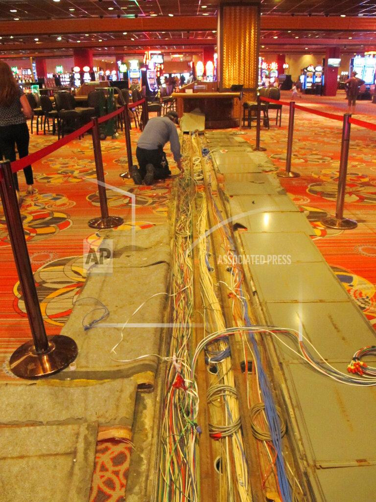 Wayne Parry A worker inspects electrical cables on the casino floor of Bally's casino in Atlantic City N.J., Monday, June 14, 2021. The new owners of Bally's Atlantic City are attempting to revive a comatose casino in perhaps the most cutthroat gambling market in America. Rhode Island-based Bally's Corporation is spending at least $90 million on the Boardwalk casino over the next five years, including hotel room makeovers, a renovation of the casino floor, new slot machines and restaurants, and more live entertainment. (AP Photo/Wayne Parry)