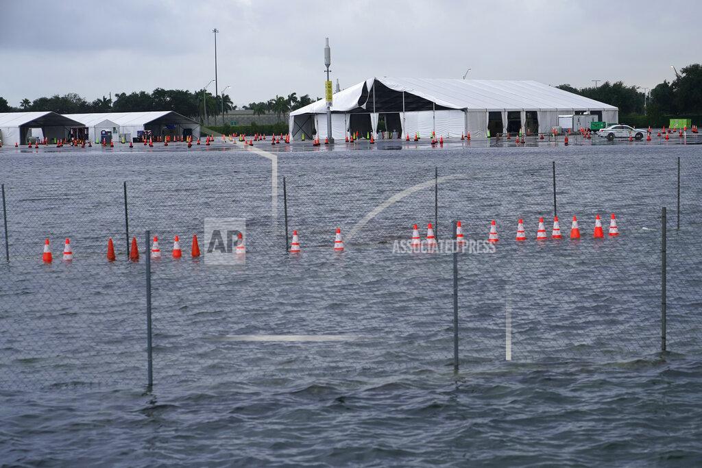 Lynne Sladky A parking lot at Hard Rock Stadium, the site of one of the major COVID-19 testing sites in the state, is flooded in the aftermath of Tropical Storm Eta, Monday, Nov. 9, 2020, in Miami Gardens, Fla. The site suffered major damage due to extensive rain dumped by the storm, and will remain closed until Wednesday or Thursday. (AP Photo/Lynne Sladky)
