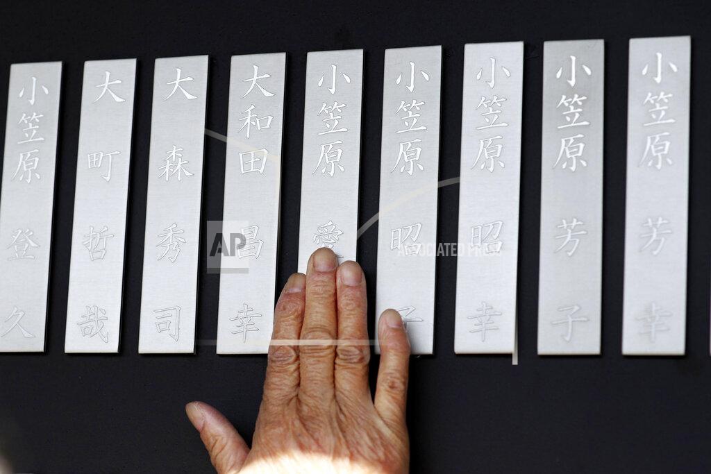 Takaki Yajima A mourner touches a name plate of a victim in the 2011 earthquake and tsunami, at Kamaishi Memorial Park in Kamaishi, Iwate prefecture, Japan Thursday, March 11, 2021. Thursday marks the 10th anniversary of the massive earthquake, tsunami and nuclear disaster that struck Japan's northeastern coast. (Takaki Yajima/Kyodo News via AP)