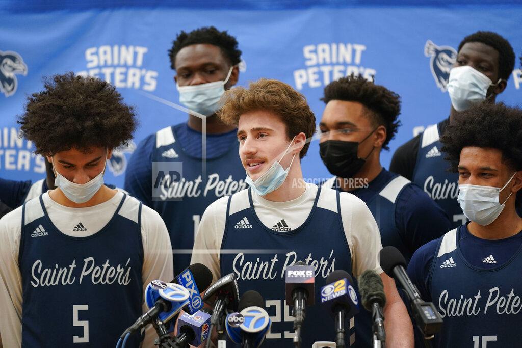 Seth Wenig Surrounded by teammates, St. Peter's Doug Edert, center, speaks to reporters before NCAA college basketball practice in Jersey City, N.J., Tuesday, March 22, 2022. (AP Photo/Seth Wenig)