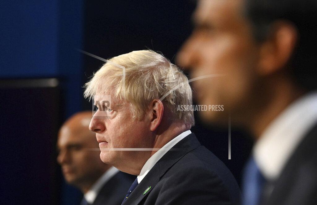 Toby Melville FILE - In this Tuesday, Sept. 7, 2021 file photo, from left, Britain's Health Secretary Sajid Javid, Prime Minister Boris Johnson and Chancellor of the Exchequer Rishi Sunak attend a media briefing in Downing Street, London. Johnson is set to announce how his government plans to control the coronavirus during the fall and winter. He is hoping vaccinations, rather than restrictions, will keep COVID-19 in check. At a news conference on Tuesday, Johnson is expected to say that mask-wearing, work-from-home advice and social distancing rules that were lifted in July could return if cases climb. (Toby Melville/Pool Photo via AP, File)