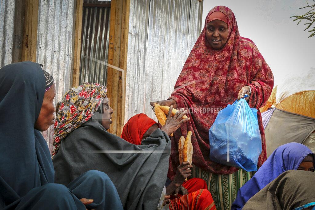Farah Abdi Warsameh Somalis who fled drought-stricken areas receive charitable food donations from city residents after arriving at a makeshift camp for the displaced on the outskirts of Mogadishu, Somalia Thursday, June 30, 2022. The war in Ukraine has abruptly drawn millions of dollars away from longer-running humanitarian crises and Somalia is perhaps the most vulnerable as thousands die of hunger amid the driest drought in decades. (AP Photo/Farah Abdi Warsameh)