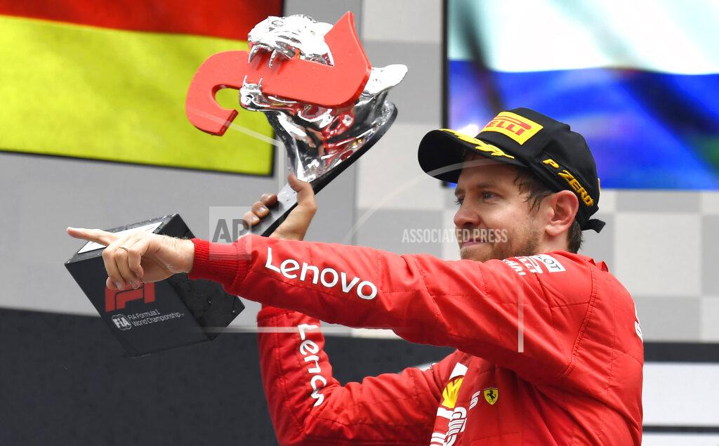 Jens Meyer Ferrari driver Sebastian Vettel of Germany celebrates on the podium after he placed second in the German Formula One Grand Prix at the Hockenheimring racetrack in Hockenheim, Germany, Sunday, July 28, 2019. (AP Photo/Jens Meyer)