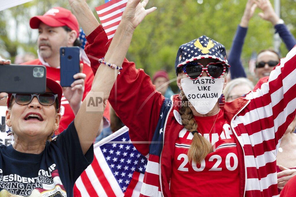 Michael Dwyer People demonstrate against state restrictions imposed over concern about COVID-19 near the residence of Gov. Charlie Baker, Saturday, May 16, 2020, in Swampscott, Mass. (AP Photo/Michael Dwyer)