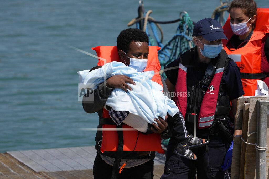 Matt Dunham A man and a child thought to be migrants are disembarked from a British border force vessel in Dover, south east England, Thursday, July 22, 2021. The number of undocumented migrants reaching Britain in small boats this year has surpassed the total for all of 2020, as people smugglers take advantage of good weather to cross the English Channel from France. (AP Photo/Matt Dunham)