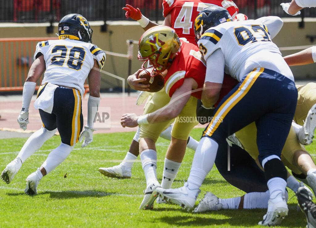 VMI quarterback Seth Morgan (4) crosses the goal line after a two-yard run with East Tennessee State's Max Evans (93) on his back for the first score of the game during the first half of an NCAA college football game Saturday, April 3, 2021, in Lexington, Va. (David Hungate/The Roanoke Times via AP)