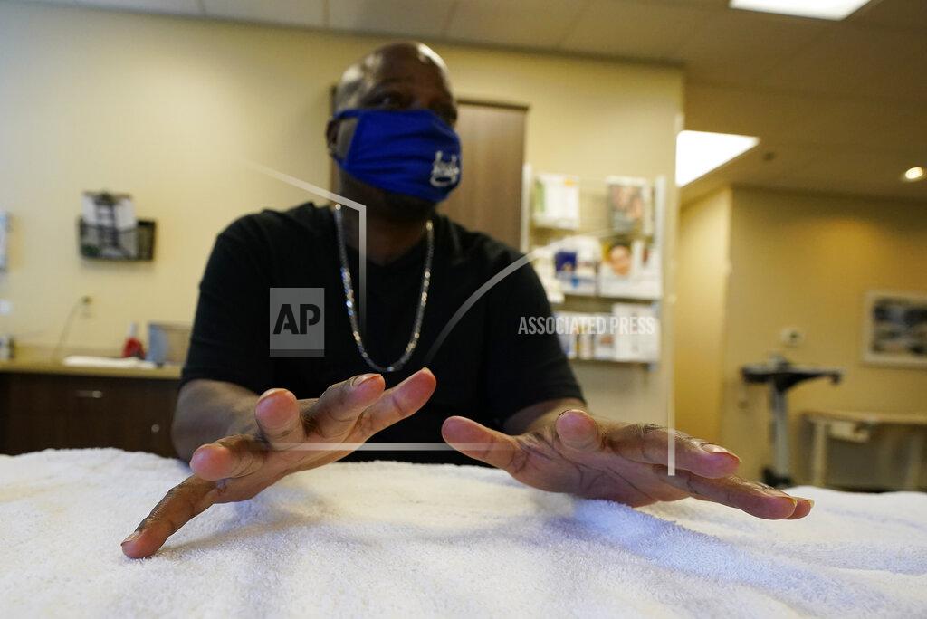 Darron Cummings Larry Brown moves his fingers during his occupational therapy session at Community Health Network, Thursday, Aug. 20, 2020, in Indianapolis. Hand therapy is twice a week. His hands, once making savvy plays on game days when he was an Indiana State football player, are now shaky when he snags a medicine ball bounced off a trampoline. (AP Photo/Darron Cummings)