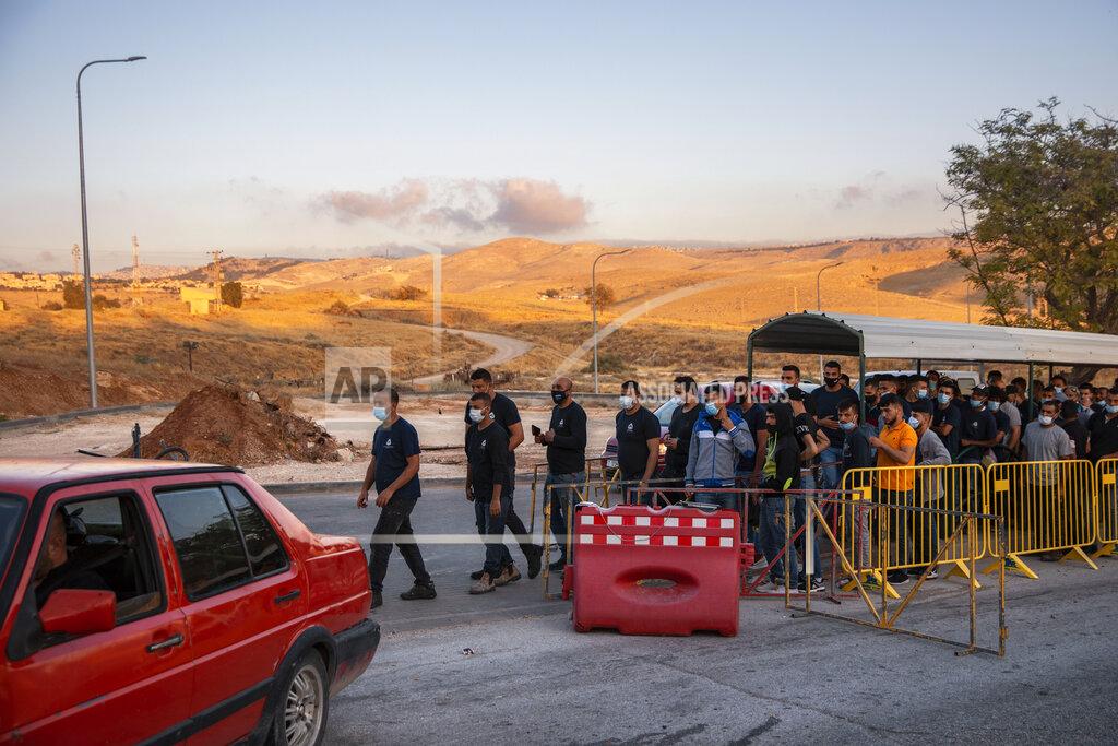 Oded Balilty Palestinians laborers line up to cross a checkpoint at the entrance to the Israeli settlement of Maale Adumim, near Jerusalem, Tuesday, June 30, 2020. Israeli Prime Minister Benjamin Netanyahu appears determined to carry out his pledge to begin annexing parts of the occupied West Bank, possibly as soon as Wednesday. (AP Photo/Oded Balilty)