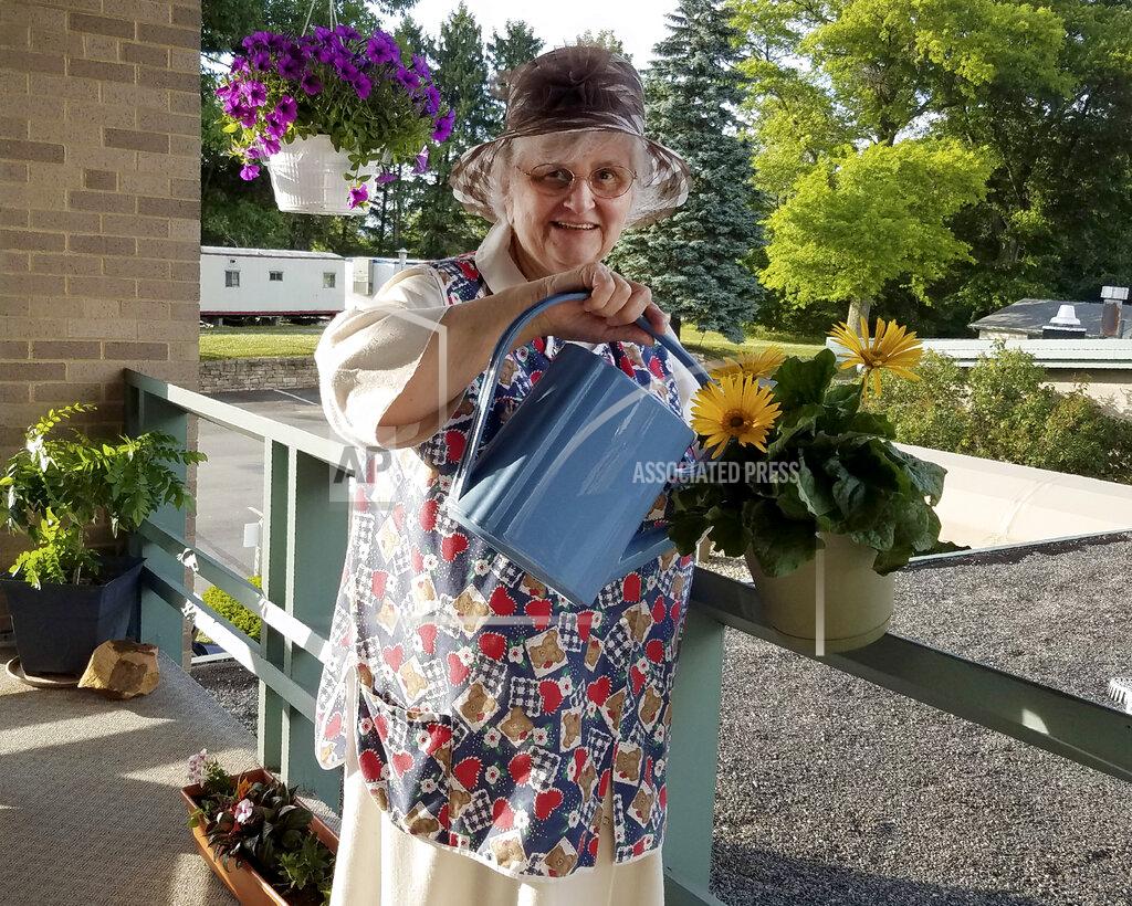 Sister Mary Jeanine Morozowich In this photo provided by Sister Mary Jeanine Morozowich, Felician Sister Mary Evelyn Labik waters flowers at St. Anne Home in Greensburg, Pa., on June 22, 2020. Labik died after contracting COVID-19 last October. (Sister Mary Jeanine Morozowich via AP)