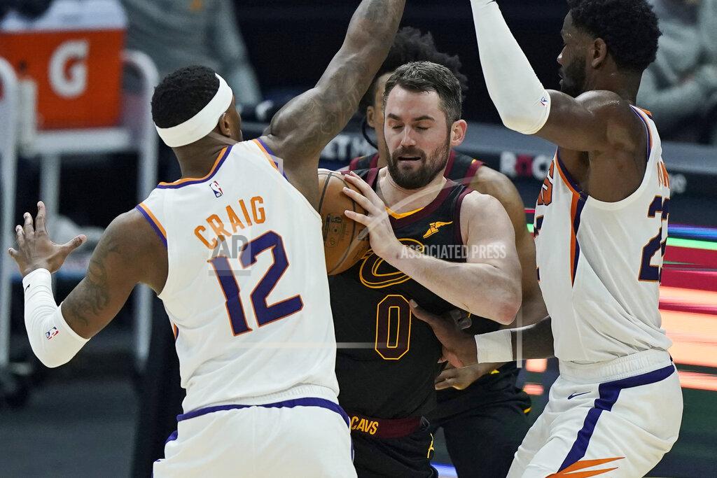Tony Dejak Cleveland Cavaliers Kevin Love, center, tries to get past Phoenix Suns' Torrey Craig, left, and Deandre Ayton, right, in the first half of an NBA basketball game, Tuesday, May 4, 2021, in Cleveland. (AP Photo/Tony Dejak)