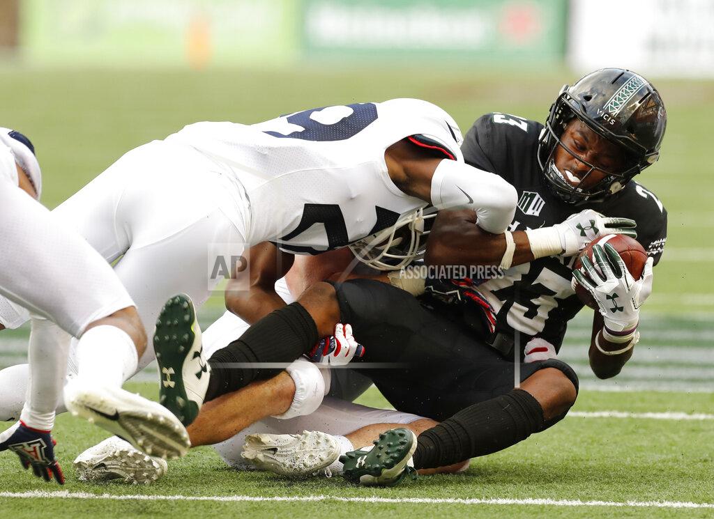 Marco Garcia Arizona linebacker Colin Schooler and safety Samari Springs (29) pull down Hawaii wide receiver Jared Smart (23) during the second quarter of an NCAA college football game Saturday, Aug. 24, 2019, in Honolulu. (AP Photo/Marco Garcia)