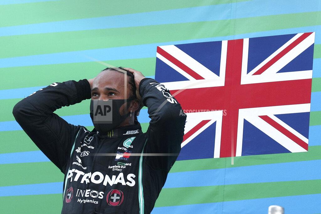 Albert Gea Mercedes driver Lewis Hamilton of Britain celebrates on the podium after the Formula One Grand Prix at the Barcelona Catalunya racetrack in Montmelo, Spain, Sunday, Aug. 16, 2020. (Albert Gea, Pool via AP)