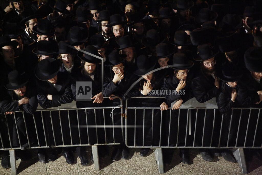 Ariel Schalit Ultra-Orthodox mourners gather around the body of Menachem Knoblowitz, 21, from Borough Park, Brooklyn in the United States, who died during Lag BaOmer celebrations at Mt. Meron in northern Israel, during his funeral in Jerusalem on Saturday, May 1 2021. A stampede at a religious festival attended by tens of thousands of ultra-Orthodox Jews in northern Israel killed dozens of people and injured about 150 early Friday, medical officials said. It was one of the country's deadliest civilian disasters. (AP Photo/Ariel Schalit)