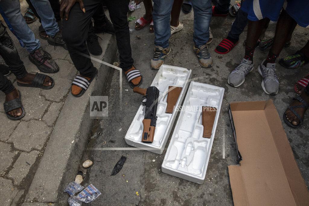 Rodrigo Abd Protesters display toy guns used by musicians who were recording a music video the night before as they explain to journalists how police opened fire on the musicians killing one of them because police thought they were carrying real weapons, during a protest in downtown in Port-au-Prince, Haiti, Wednesday, Sept. 22, 2021. (AP Photo/Rodrigo Abd)